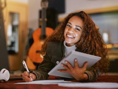 Black woman, portrait smile and tablet writing music in studio for audio track, content creation or