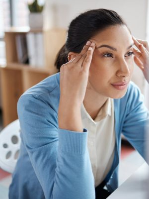 Shot of a young businesswoman looking stressed while using a laptop at her desk in a modern office